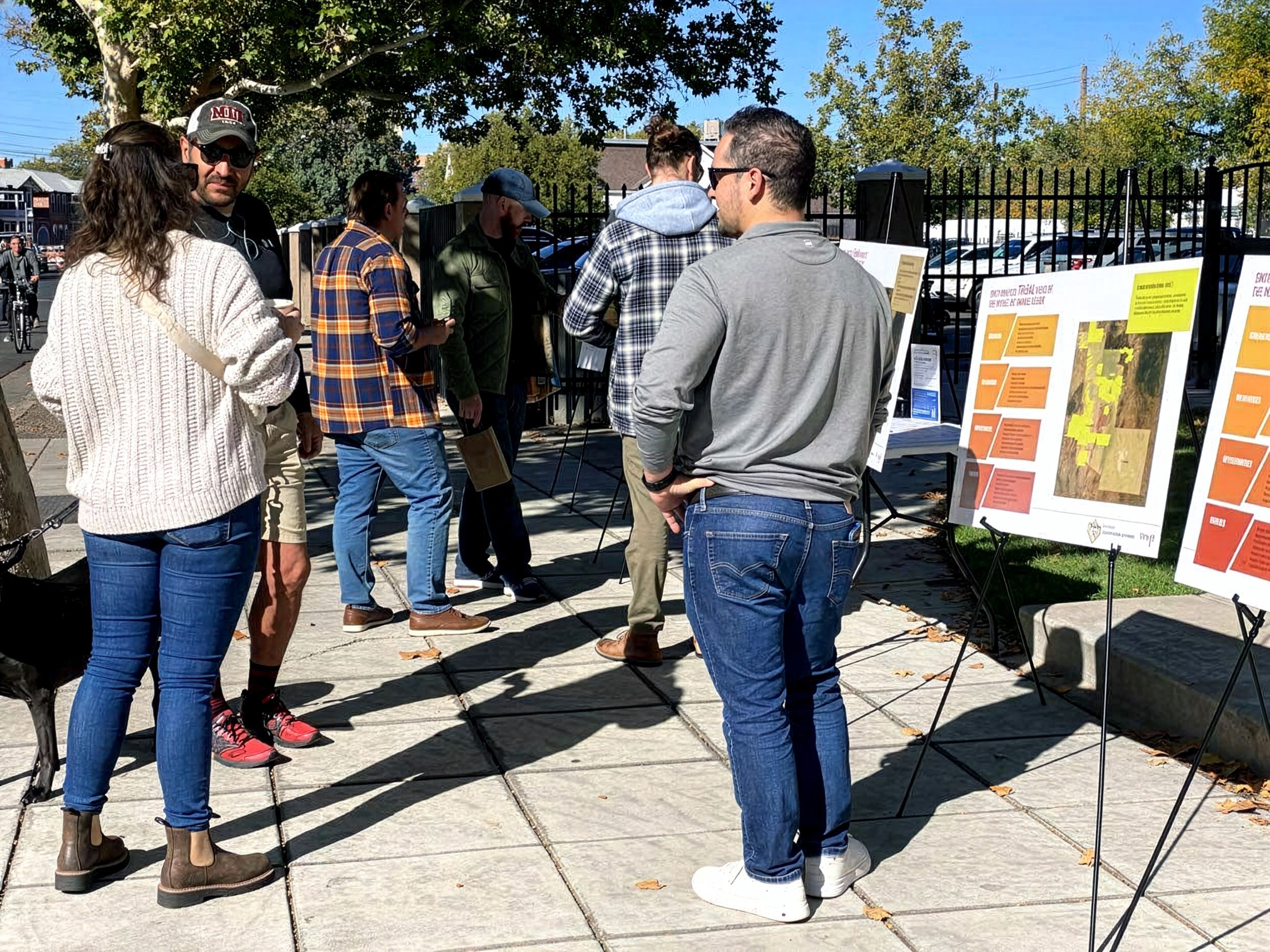 Folks standing around looking at informational boards.